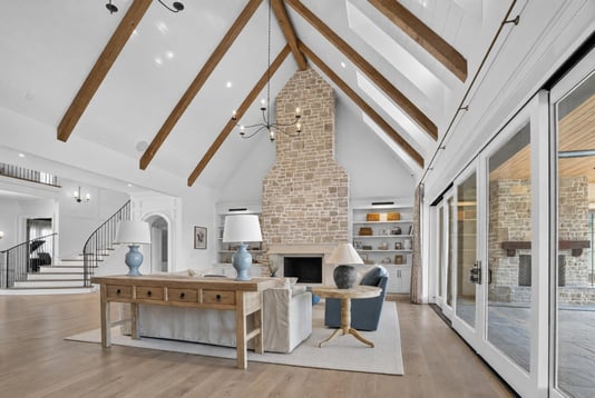 High ceiling living room with fireplace by Wolfe Homes