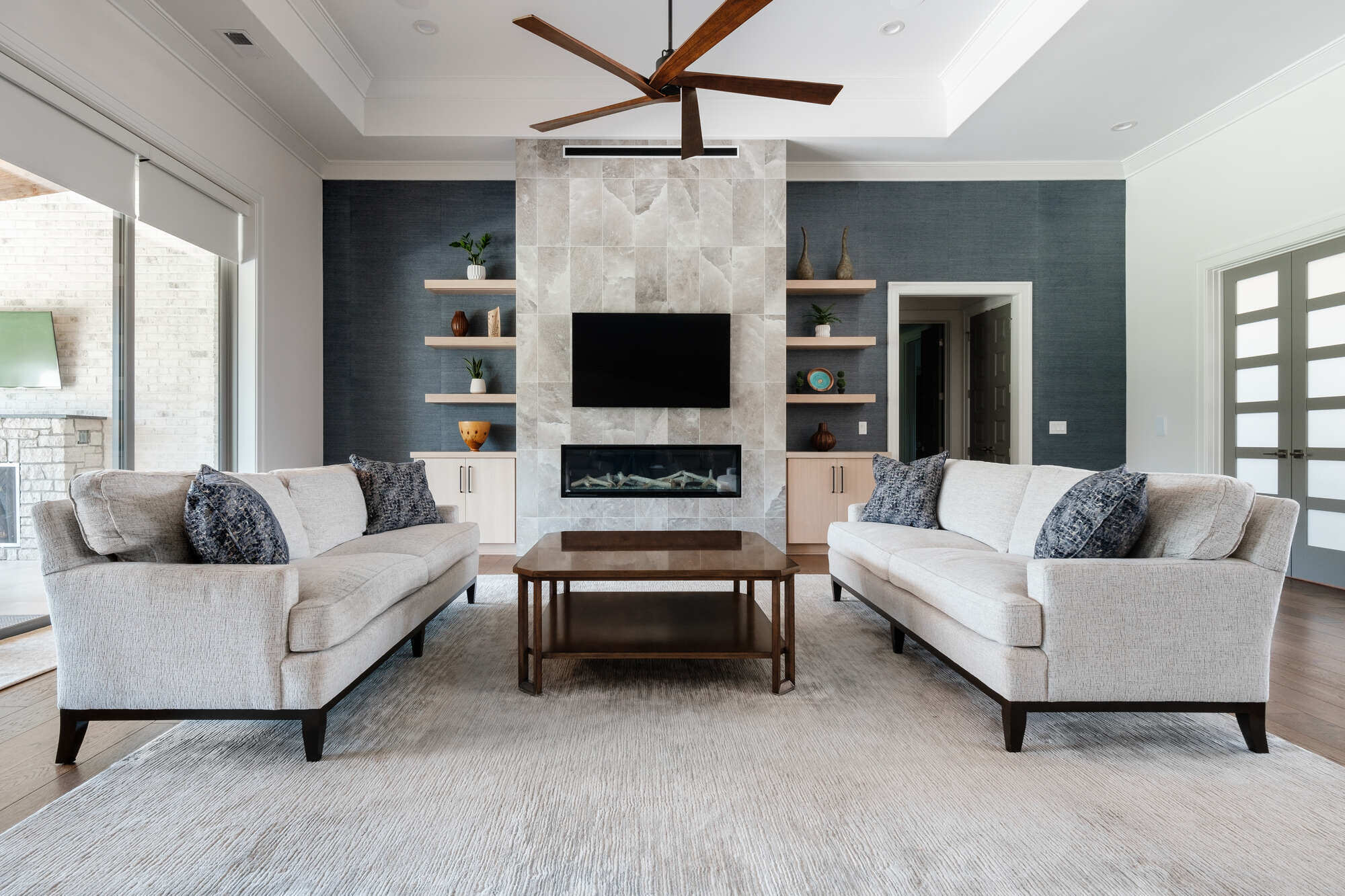 Modern living room with fireplace and built-in shelving in Greensboro custom home by Wolfe Homes