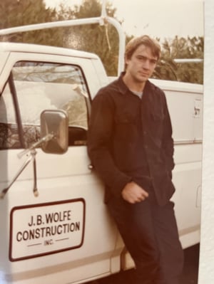 Vintage photo of Jim Wolfe standing next to a J.B. Wolfe Construction truck in Greensboro, NC