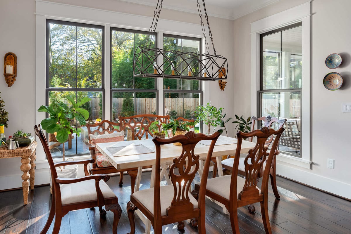 Custom dining area remodel in Greensboro, NC by Wolfe Homes, featuring large windows and lush greenery