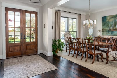Custom foyer and dining area remodel in Greensboro, NC by Wolfe Homes, featuring rich wooden entry doors