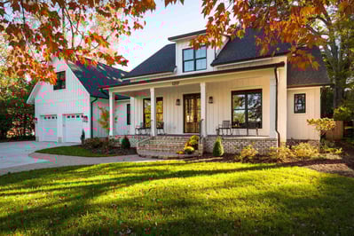 Front exterior view of custom remodeled Greensboro home by Wolfe Homes with a welcoming porch and fall decor