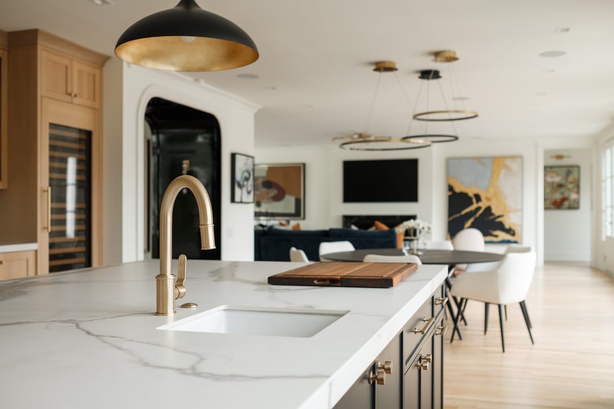 Modern elegant kitchen with granite countertops and light cabinetry and gold fixtures