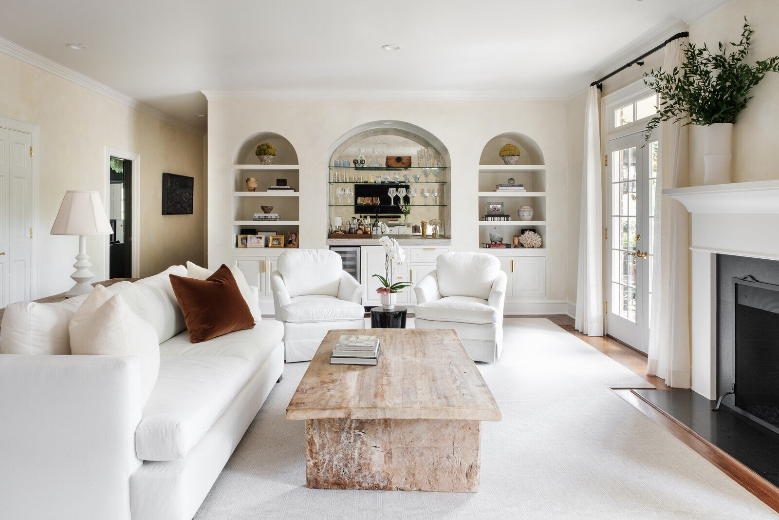 Bright, modern living room with white furniture and built-in shelves in a Greensboro custom remodel by Wolfe Homes