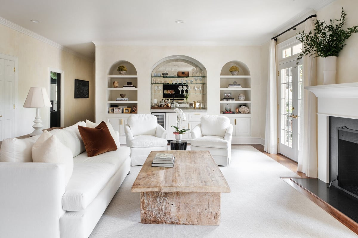 Bright, modern living room with white furniture and built-in shelves in a Greensboro custom remodel by Wolfe Homes