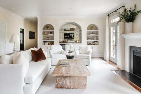 Bright, modern living room with white furniture and built-in shelves in a Greensboro custom remodel by Wolfe Homes