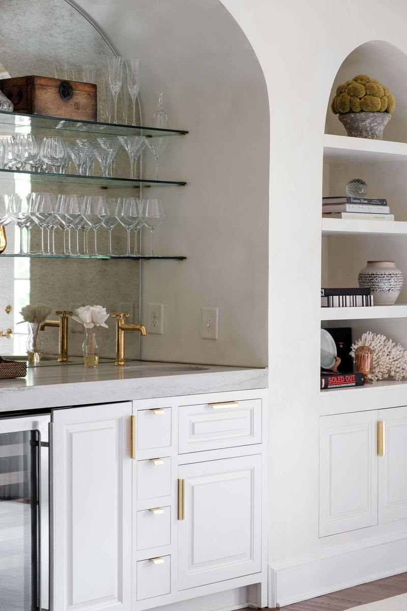 Close-up of a built-in bar with glass shelving in a custom home remodel by Wolfe Homes in Greensboro, NC