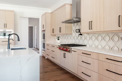 Stylish kitchen backsplash and cabinetry design by Wolfe Homes in a custom Greensboro home