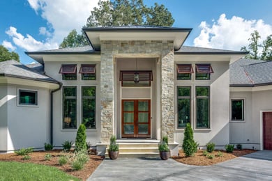 Front entrance of custom Greensboro home by Wolfe Homes with stone accents and modern windows