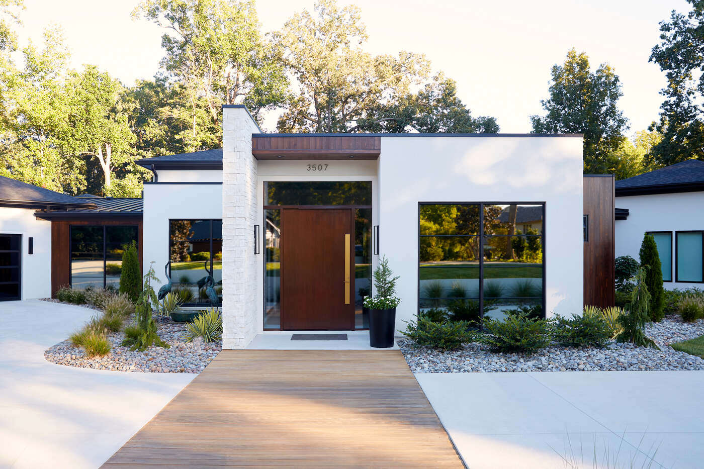 Modern custom home exterior in Greensboro by Wolfe Homes, featuring a stone-accented entrance and large garage