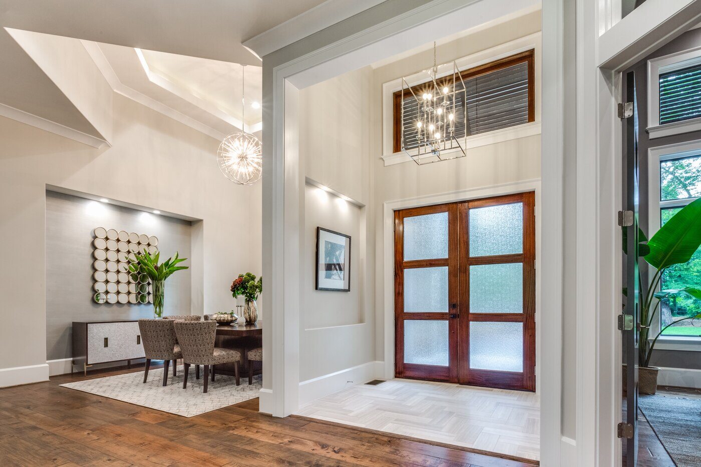 Spacious entryway in a Greensboro custom home by Wolfe Homes, featuring a wooden double door and modern light fixtures