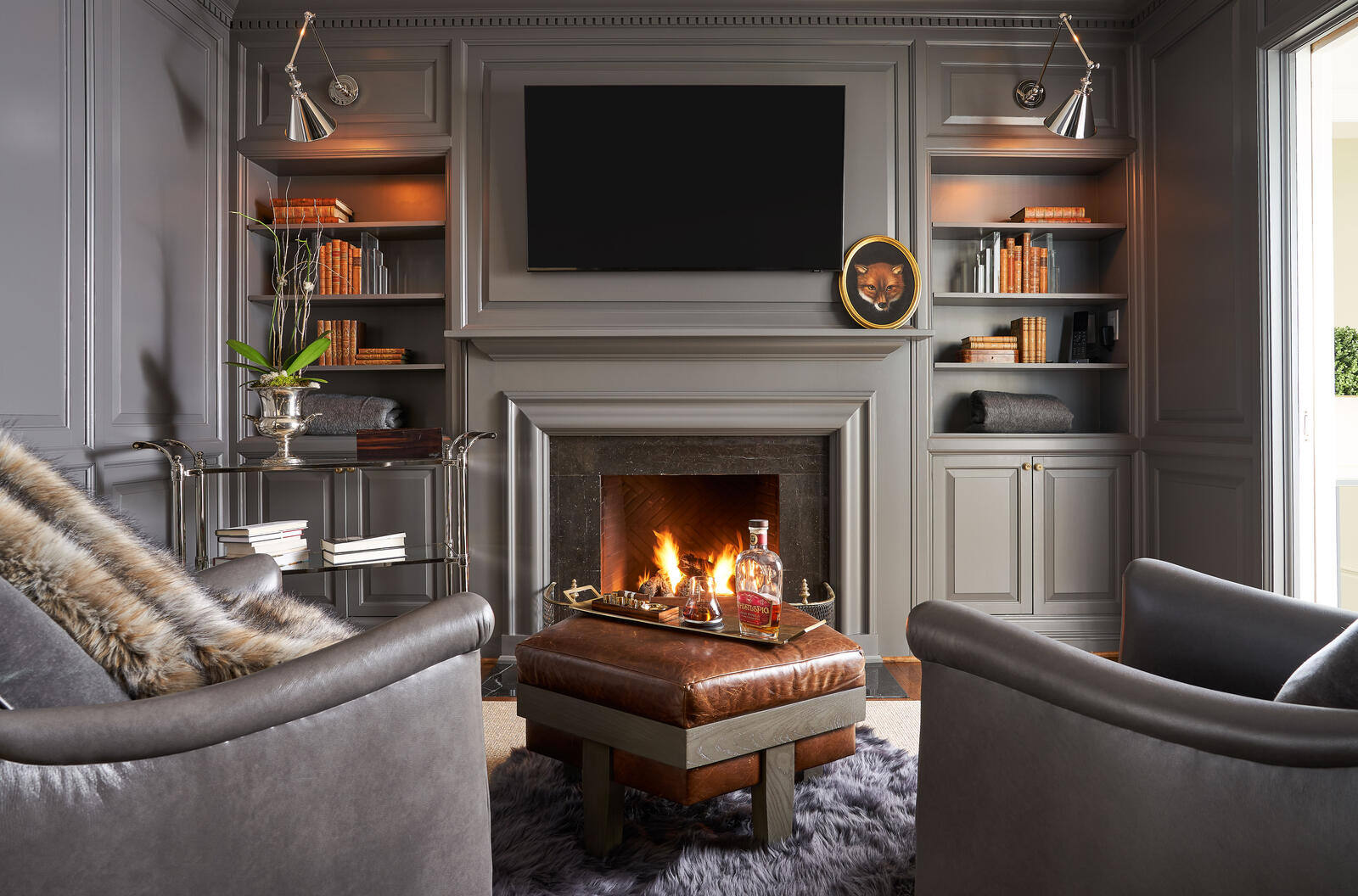 Sophisticated living room with a gray fireplace and leather chairs, remodeled by Wolfe Homes in Greensboro, NC