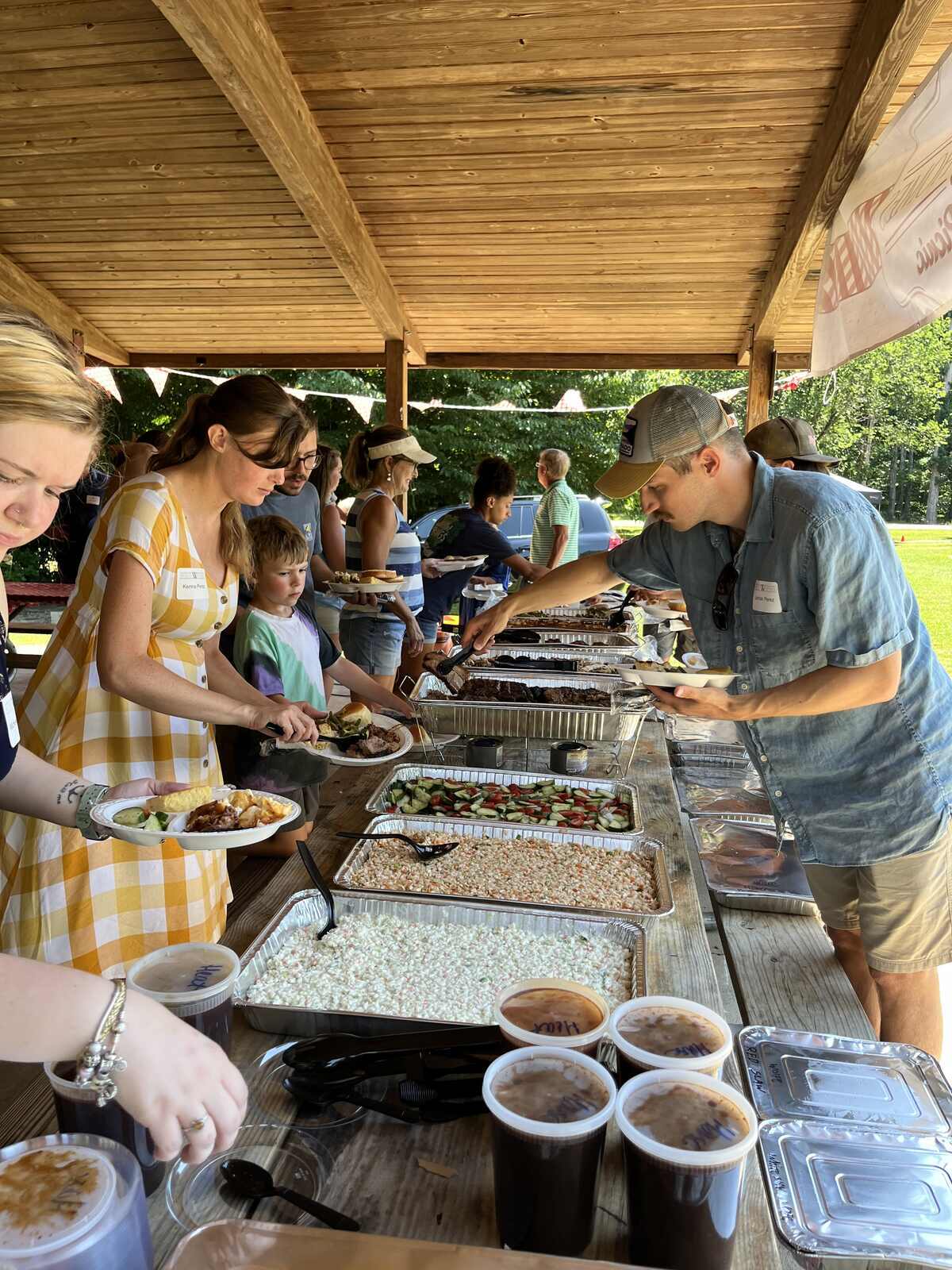 Wolfe Homes company picnic in Greensboro, NC, featuring staff enjoying a buffet spread under a pavilion