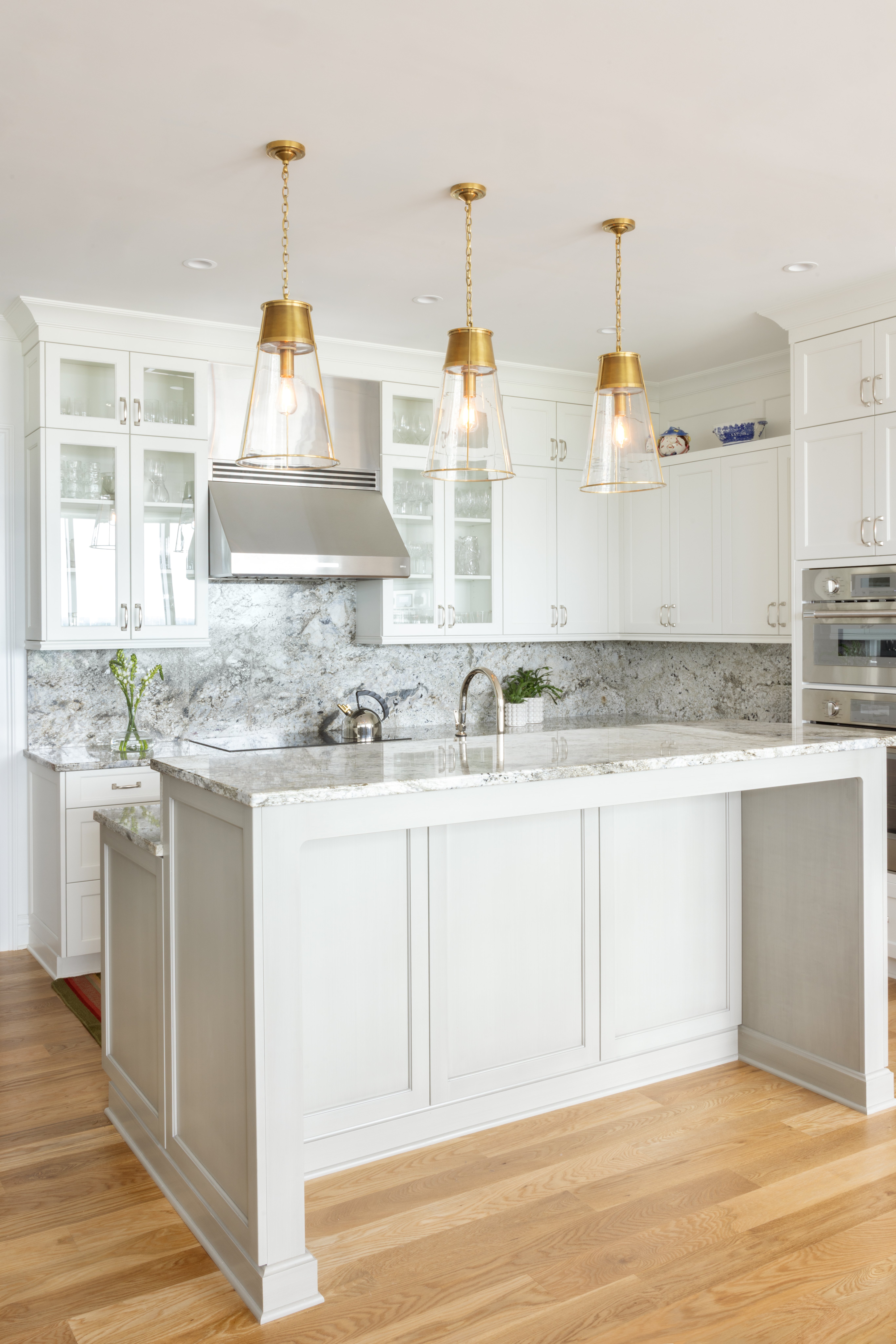 Modern white kitchen with natural light and light wood flooring in Greensboro, NC by Wolfe Homes