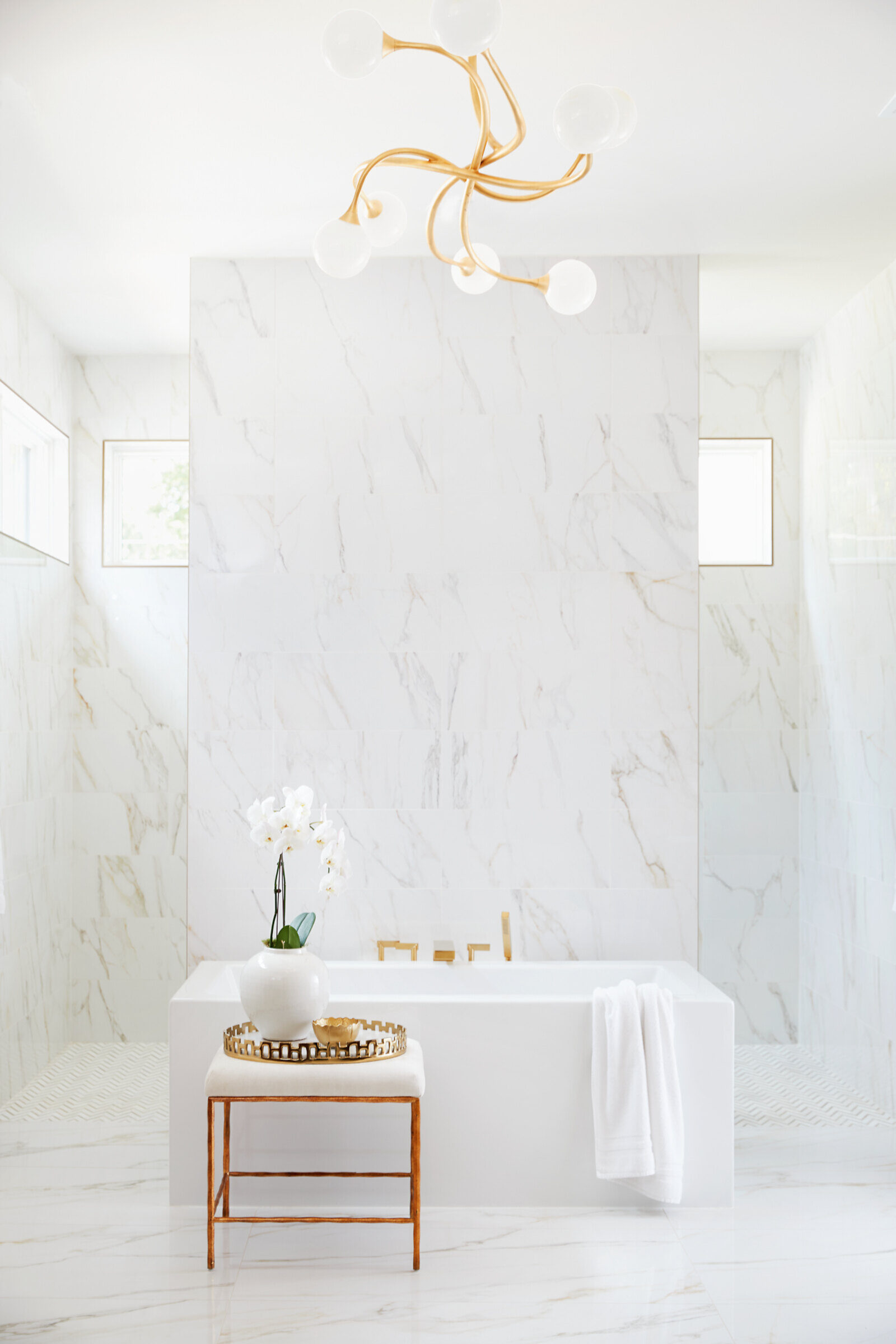Minimalist white marble bathroom with a modern soaking tub, designed by Allen & James in Gaston County