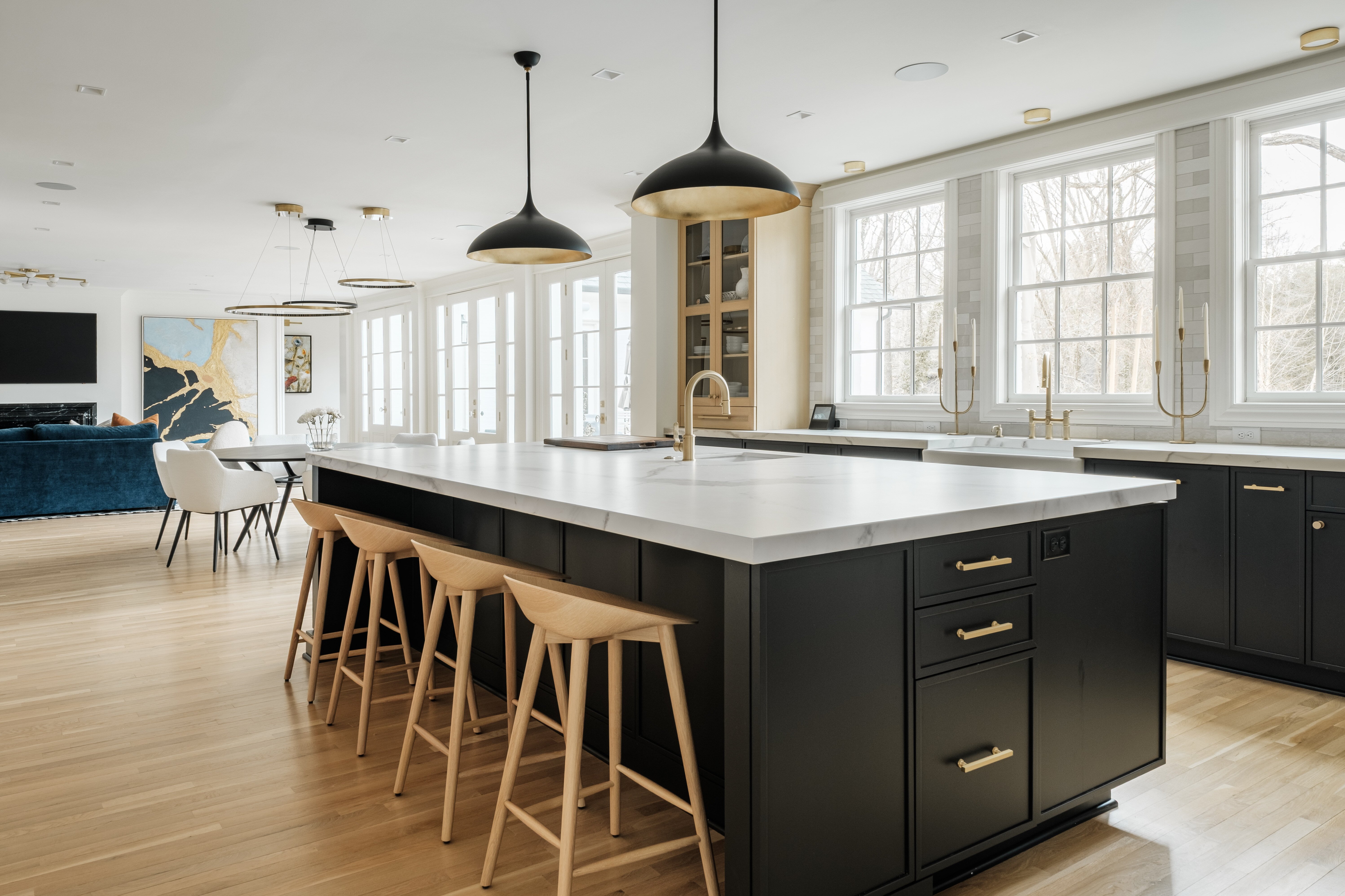Modern open-concept kitchen and dining area with hardwood floor and dark cabinetry in High Point, NC by Wolfe Homes