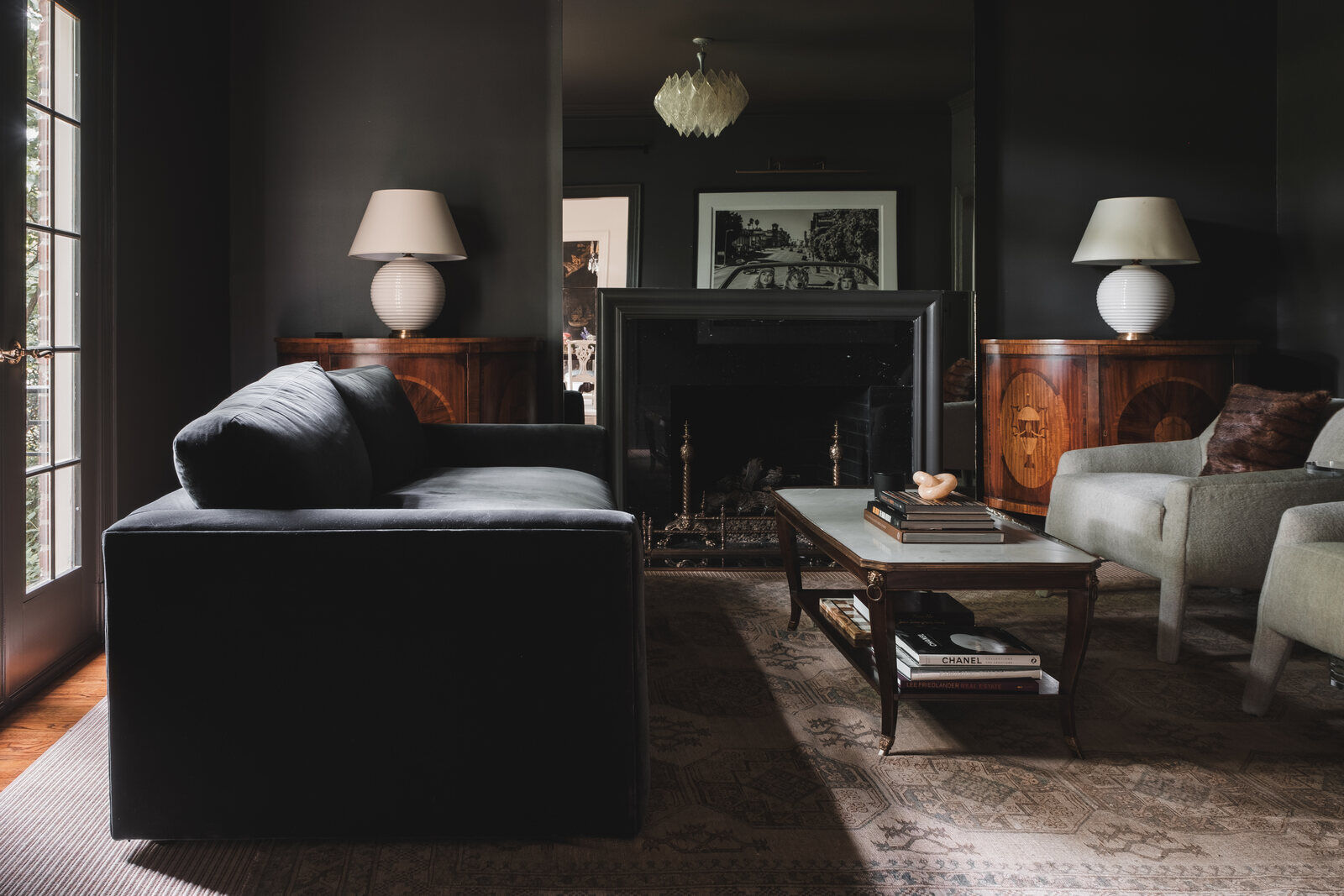 Elegant living room with dark walls, plush seating, and a vintage fireplace in a custom Greensboro remodel by Wolfe Homes