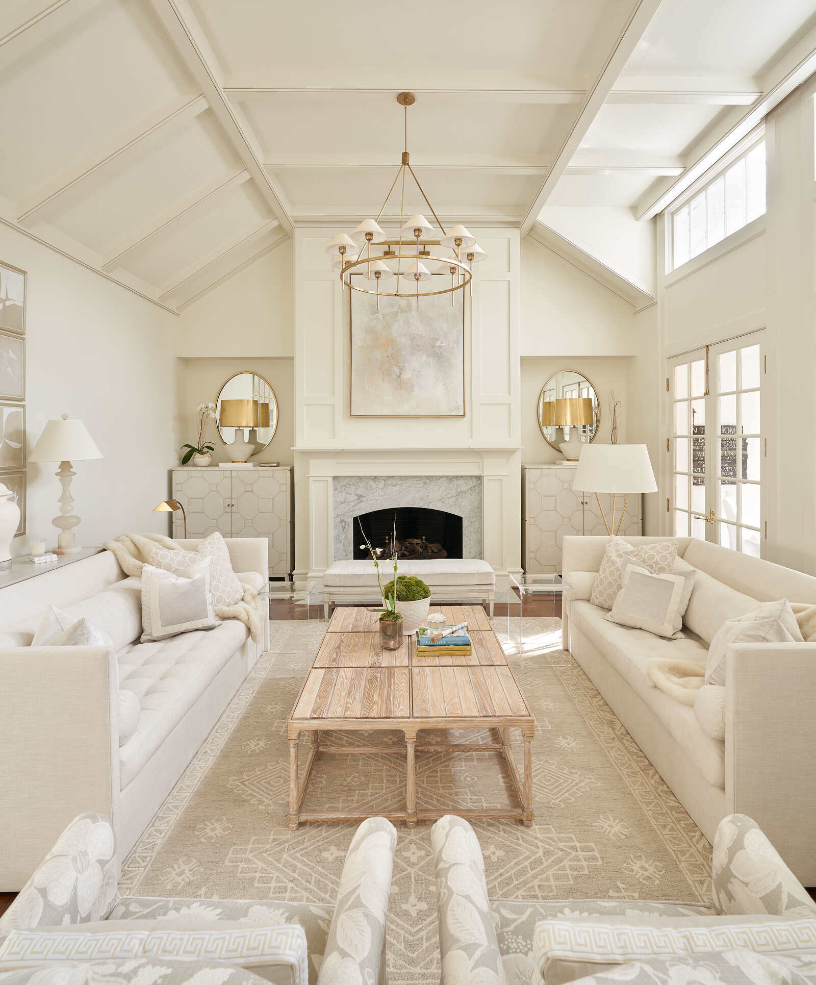 Light-filled living room with a fireplace and neutral decor by Wolfe Homes in Greensboro, NC