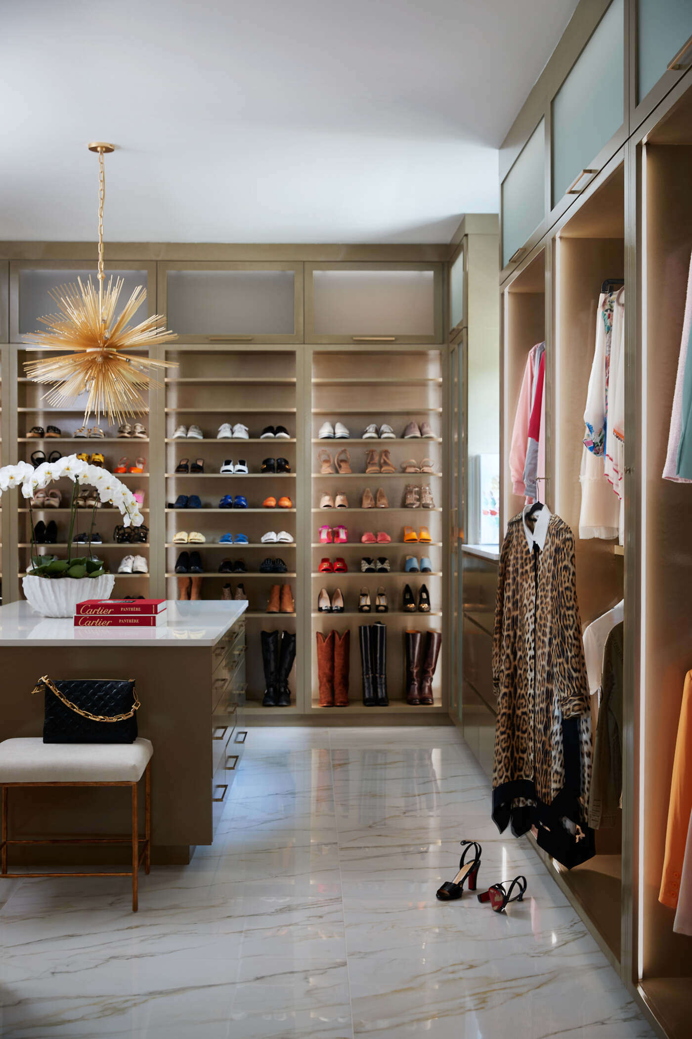 Elegant walk-in closet in Greensboro custom home by Wolfe Homes, featuring organized shelving and stylish lighting