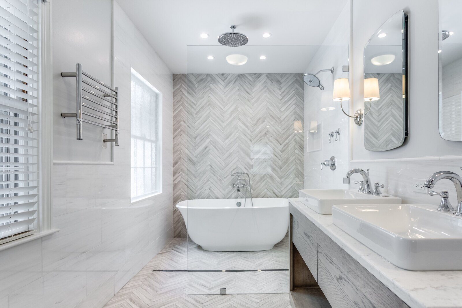 Luxurious custom bathroom remodel featuring a freestanding tub and herringbone tile design by Wolfe Homes in Greensboro, NC