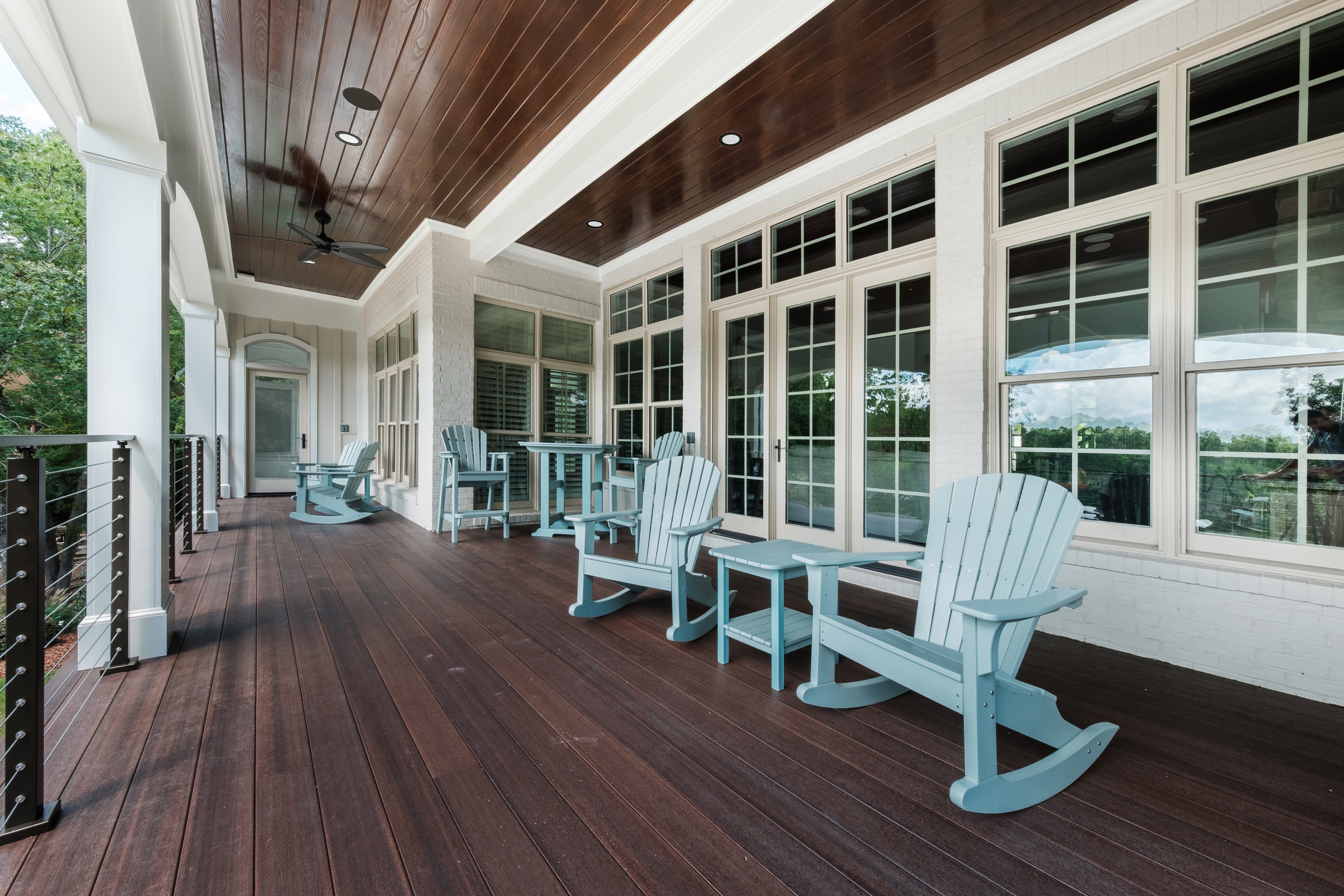 Custom back porch with dark wood paneling by Wolfe Homes
